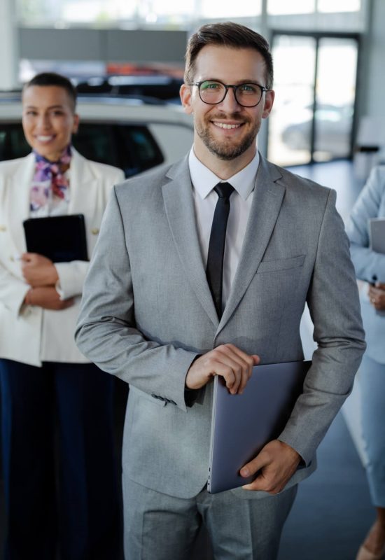 salesteam-in-dealership-three-beautiful-consultants-or-managers-in-elegant-suit-looking-on-camera-